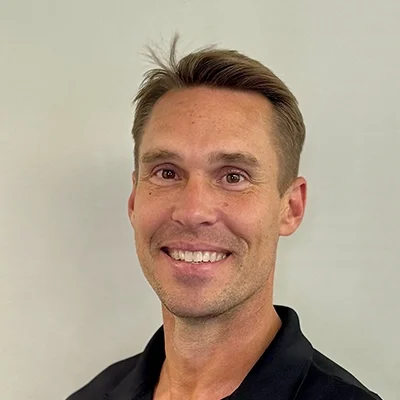 Uri Ondras smiling in a black shirt.